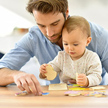 Un père aide son enfant à faire un puzzle